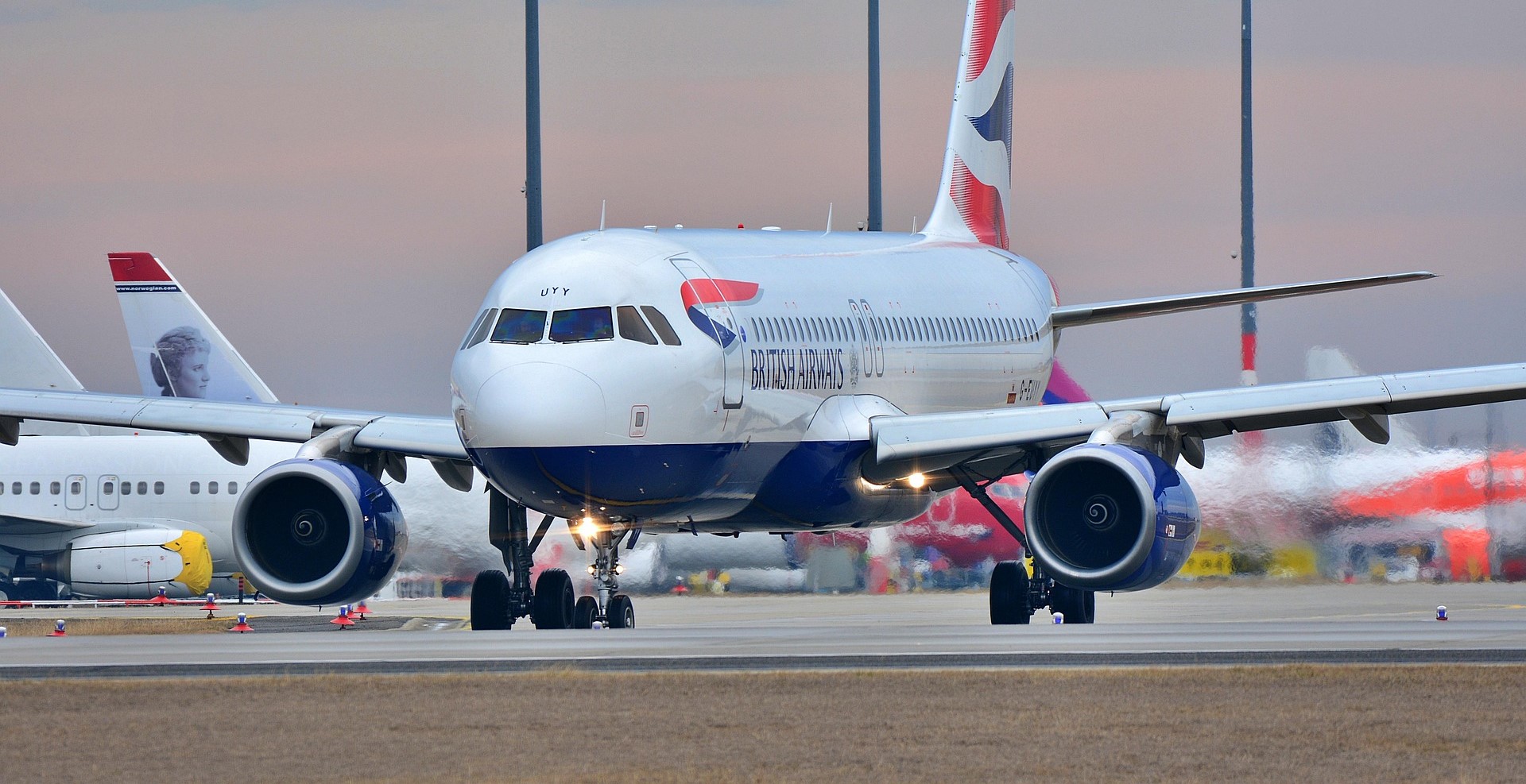 Cinematic view of a plane wing flying above clouds at sunset